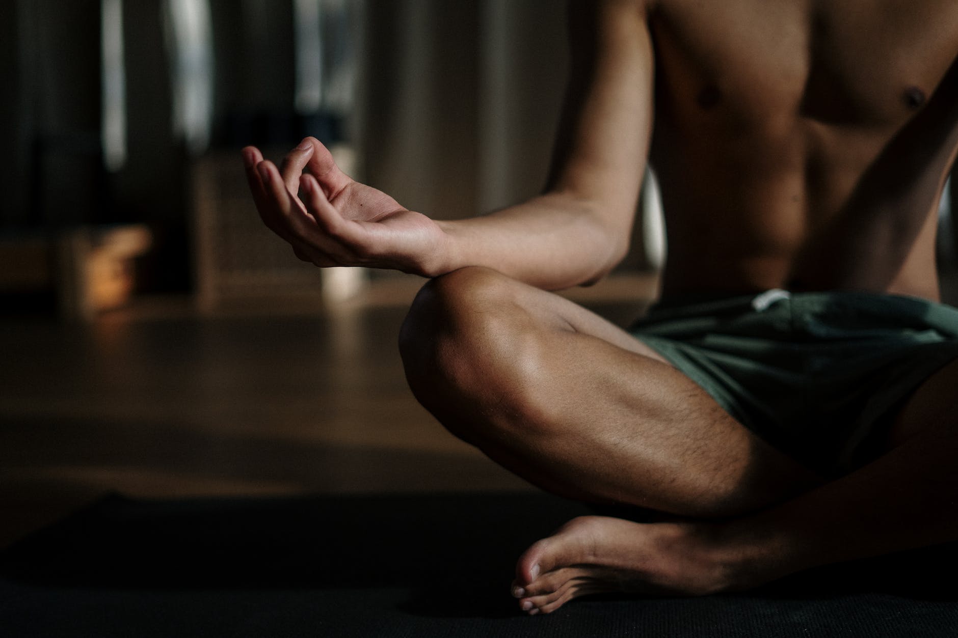 man in black shorts sitting on floor