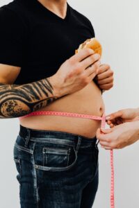 man with hamburger getting his waist measured