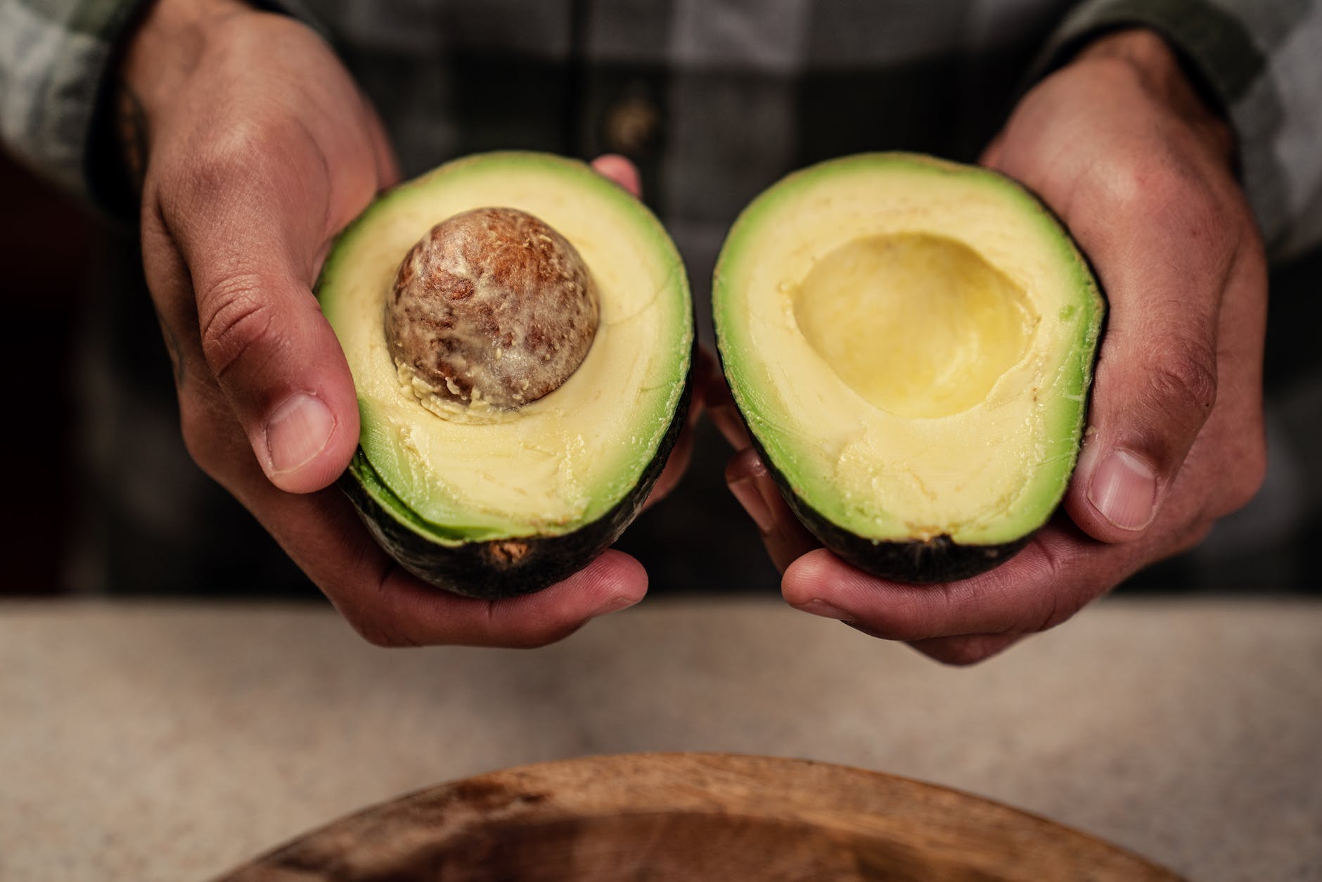 man showing halved avocado with seed