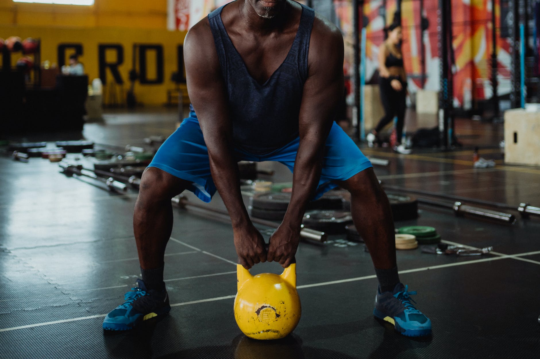 photo of man using yellow kettlebell